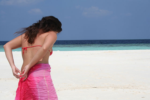 Une femme avec un paréo à la plage