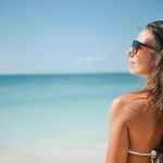 Une fille avec une paire de lunettes de soleil à la plage