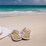 Une vue d'une paire de tongs à la plage avec un chapeau