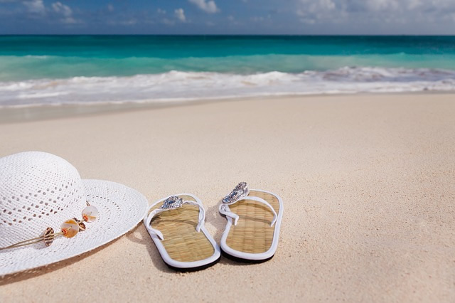 Une vue d'une paire de tongs à la plage avec un chapeau